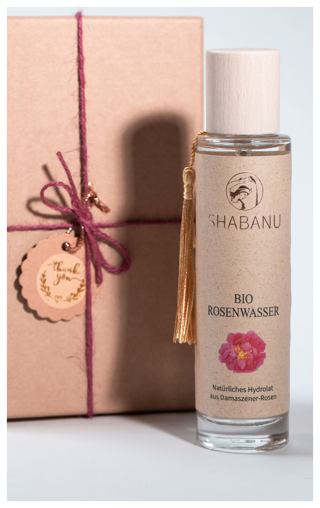 Eine Flasche SHABANU Bio-Rosenwasser aus Damaszener-Rosen neben einer Geschenkverpackung